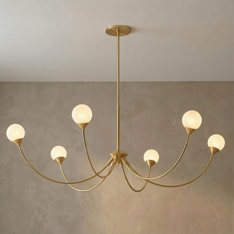 Isabella 6 Light Aged Brass globe design Chandelier in a Contemporary Dining Room with a textured plaster wall.