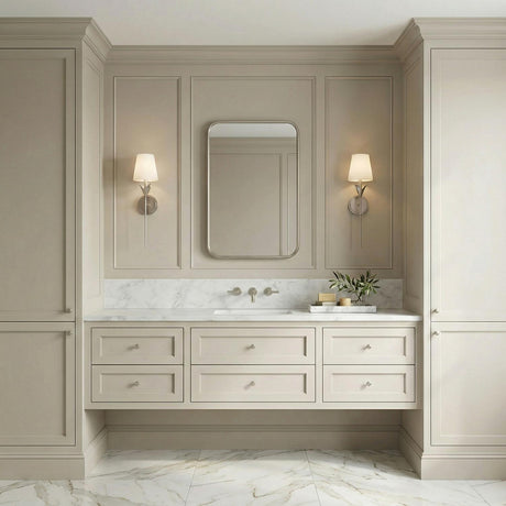 Silver leaf design wall sconce in a Transitional Bathroom with a white marble vanity and taupe wall paneling.