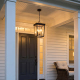 Radcliffe Outdoor Hanging Light 12", Old Bronze geometric Outdoor Hanging in a Colonial Outdoor with a wicker chair and dark door.