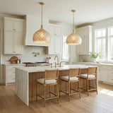 A coastal kitchen features two Valentina Large Pendant 21-inch Soft Brass and Capiz Shell pendants over a white marble waterfall island and white shaker cabinets.
