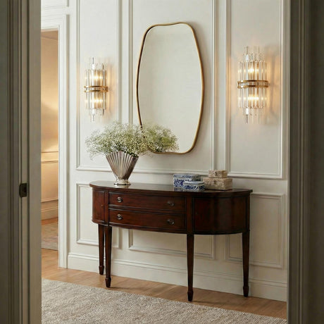 Maxwell Large Wall Sconce 20", Crystal with Aged Brass linear wall sconce in a Transitional Entryway with a dark wood console and gold mirror.