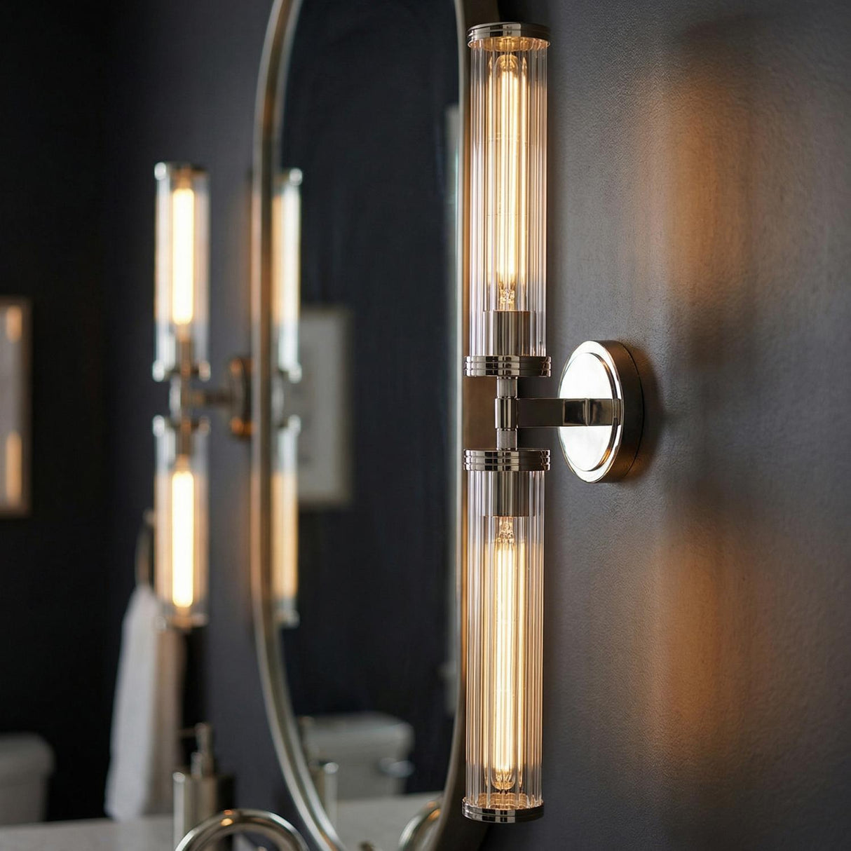 Dexter 2 Light Wall Sconce 29", Polished Nickel linear Wall Sconce in a Contemporary Bathroom with an oval mirror.