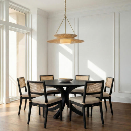 Maura Brass and Natural Fiber woven tiered pendant in a Transitional Dining Room with a round black table and cane-back chairs.