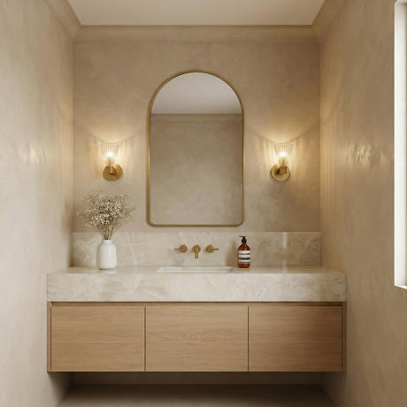 Eliza Wall Sconce 9", Brass and Clear Ribbed Glass scalloped Wall Sconce in a Contemporary Bathroom with an arched mirror and marble vanity.