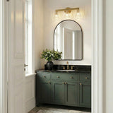 Eliza 3 Light Vanity, Brass and Clear Ribbed Glass linear Vanity in a Transitional Bathroom with a dark green vanity and arched mirror.