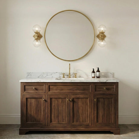 Victoria 2 Light Aged Brass and Clear Ribbed Glass globe Wall Sconce in a Traditional Bathroom with a white marble vanity and gold mirror.