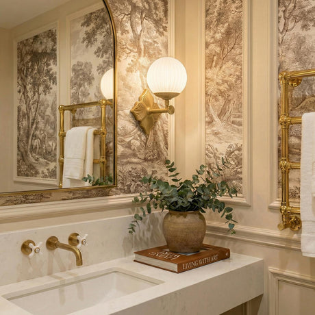 Victoria Wall Sconce 12", Aged Brass and Opal Ribbed Glass globe wall sconce in a Traditional Bathroom with toile wallpaper and marble vanity.