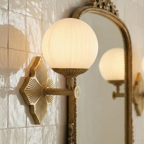 Victoria Wall Sconce 12", Aged Brass and Opal Ribbed Glass globe Wall Sconce in a Traditional Bathroom with a gold ornate mirror.