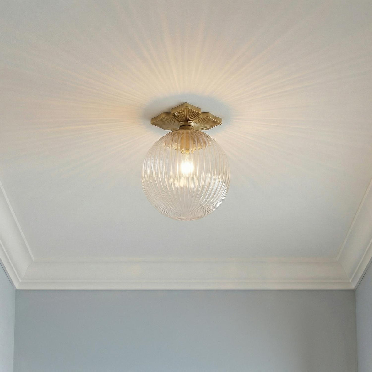 Victoria Semi-Flush 10", Aged Brass and Clear Ribbed Glass scalloped globe Flush Mount in a Traditional Hallway with classic crown molding.