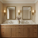 Kellan Wall Sconce 18", Aged Brass linear Wall Sconce in a Transitional Bathroom with a reeded wood double vanity and marble backsplash.