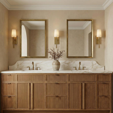 Kellan Wall Sconce 18", Aged Brass linear Wall Sconce in a Transitional Bathroom with a reeded wood double vanity and marble backsplash.