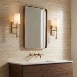 Kellan Wall Sconce 18", Aged Brass geometric wall sconce in a Contemporary Bathroom with travertine tile and walnut vanity.