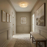 Clark LED Medium Flush Mount 16", Aged Brass and Alabaster globe flush mount in a Transitional Hallway with neutral wainscoting.