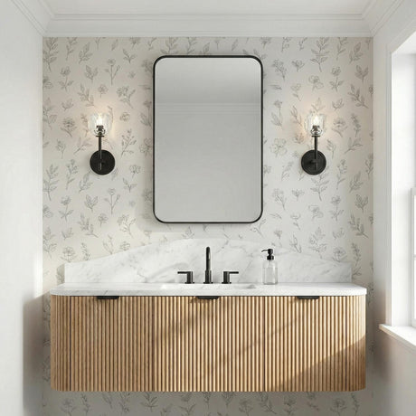 Silas Matte Black faceted crystal Wall Sconce in a Transitional Bathroom with a fluted wood vanity and marble countertop.