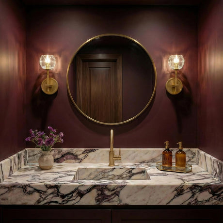 Silas Wall Sconce, Soft Brass faceted crystal wall sconce in a Contemporary Bathroom with a marble vanity and burgundy walls.