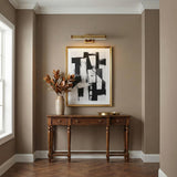 Spencer LED Picture Light 20", Brass with Brown Leather linear Wall Sconce in a Transitional Entryway with a wooden console table.