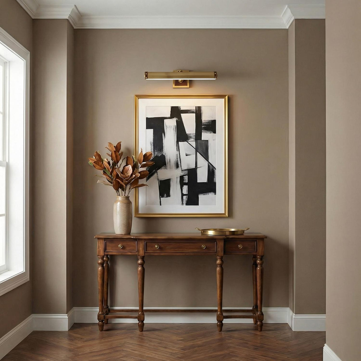 Spencer LED Picture Light 20", Brass with Brown Leather linear Wall Sconce in a Transitional Entryway with a wooden console table.
