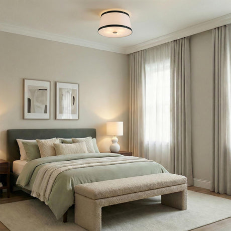 White and Matte Black geometric flush mount in a Transitional Bedroom with a green upholstered bed and textured bench.