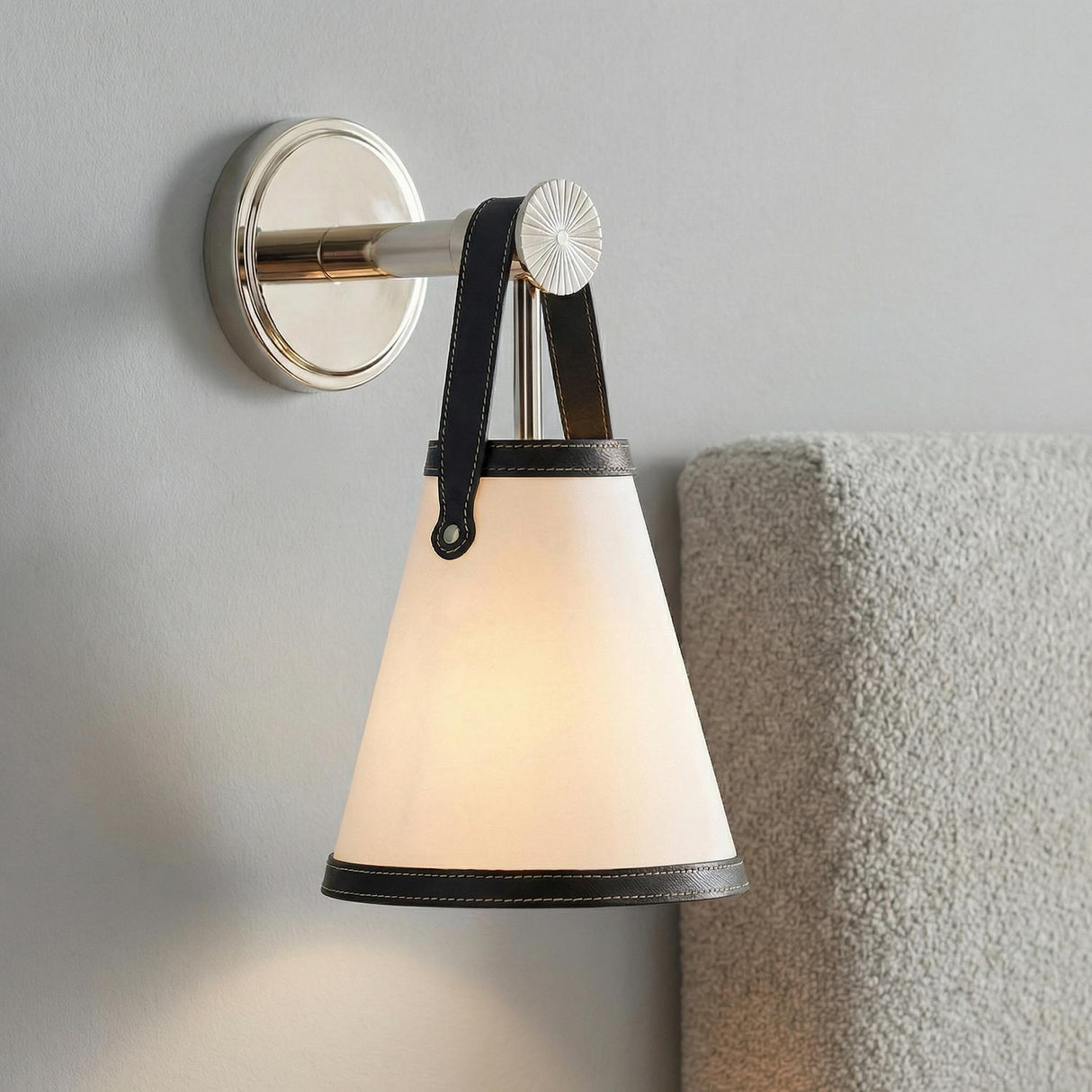 Spencer Wall Sconce, Polished Nickel with Black Leather geometric wall sconce in a Contemporary Bedroom with a grey bouclé headboard.