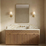 Atticus Brass geometric wall sconce in a Transitional Bathroom with a fluted wood vanity and marble backsplash.