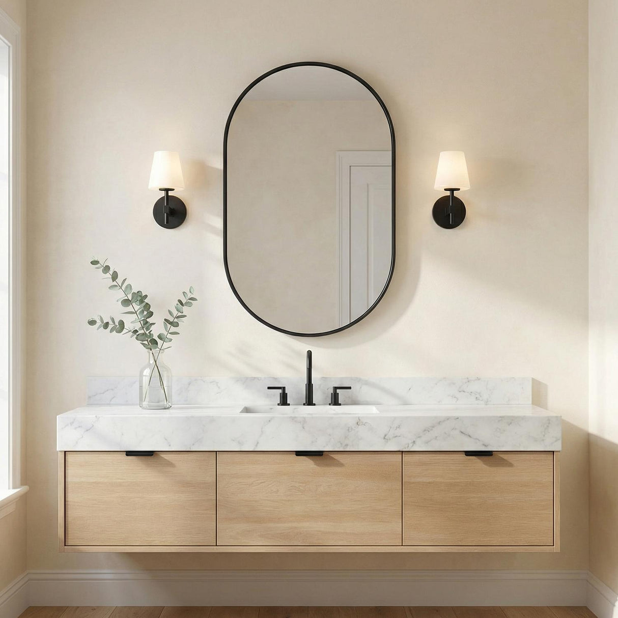 Atticus Wall Sconce 11", Black and White geometric Wall Sconce in a Modern Bathroom with a white marble vanity and oval mirror.