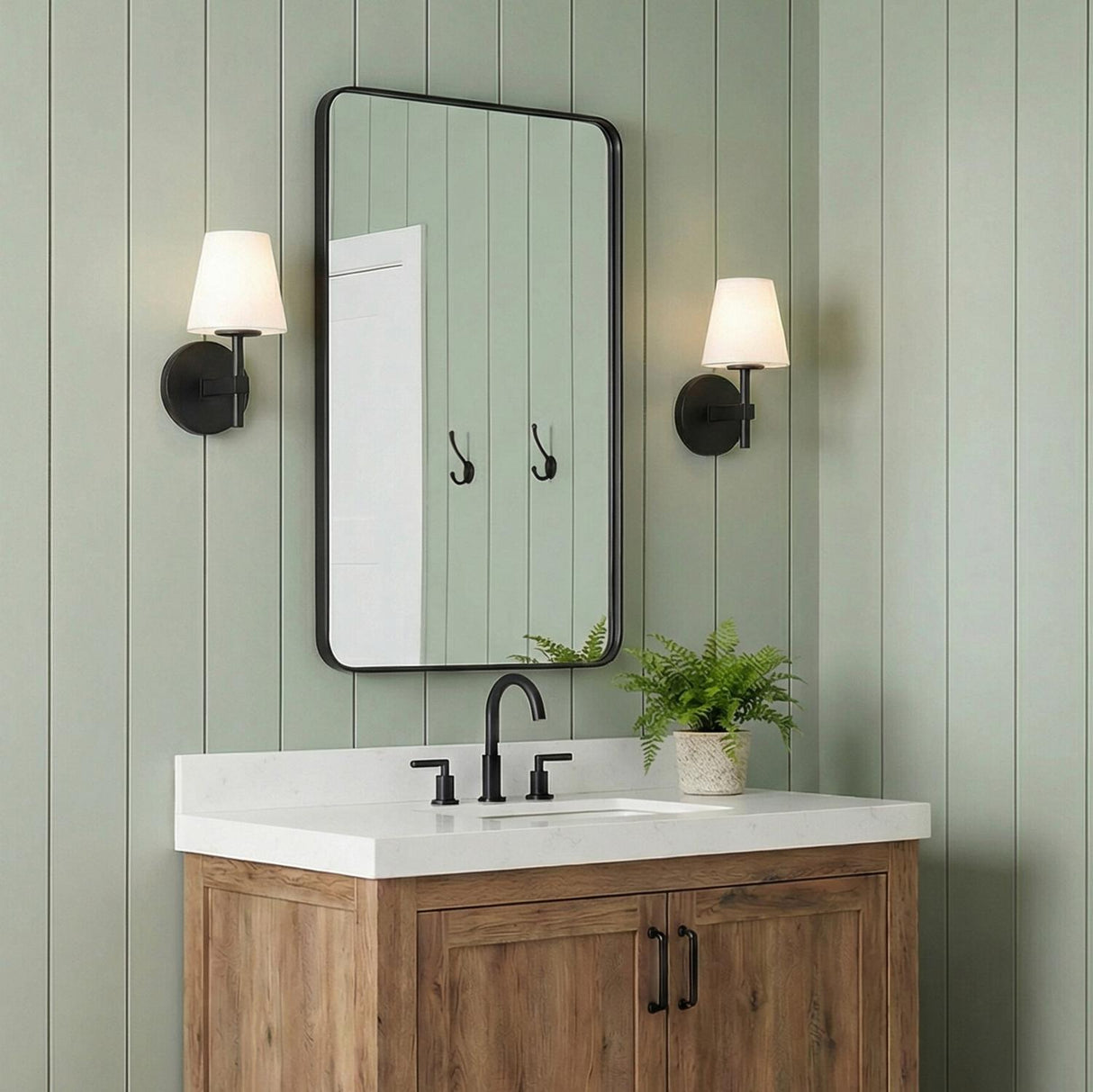 Atticus Wall Sconce 11", Black and White geometric Wall Sconce in a Modern Farmhouse Bathroom with a wood vanity and green paneling.