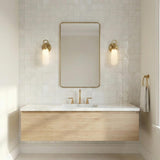 Finnian LED Wall Sconce 13", Brass globe Wall Sconce in a Contemporary Bathroom with a white marble vanity and gold mirror.