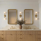Ashton 2 Light Wall Sconce, Brass globe design Wall Sconce in a Contemporary Bathroom with a double vanity and fluted wood cabinets.
