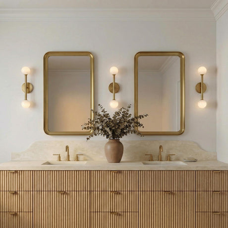Ashton 2 Light Wall Sconce, Brass globe design Wall Sconce in a Contemporary Bathroom with a double vanity and fluted wood cabinets.