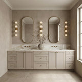 Ashton 4 Light Wall Sconce, Brass and Strie Glass globe wall sconce in a Transitional Bathroom with a double vanity and oval mirrors.