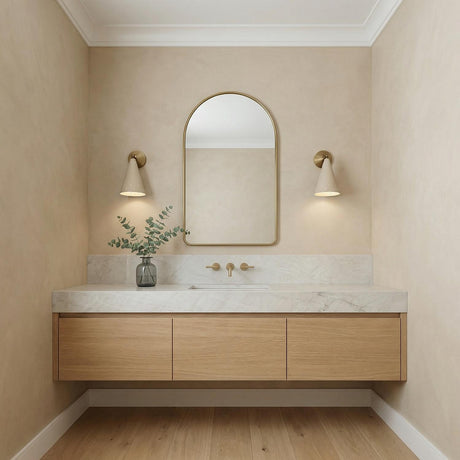 Jerico Adjustable Wall Sconce 13", Soft Sand and Patina Brass geometric Wall Sconce in a Contemporary Bathroom with an arched mirror.