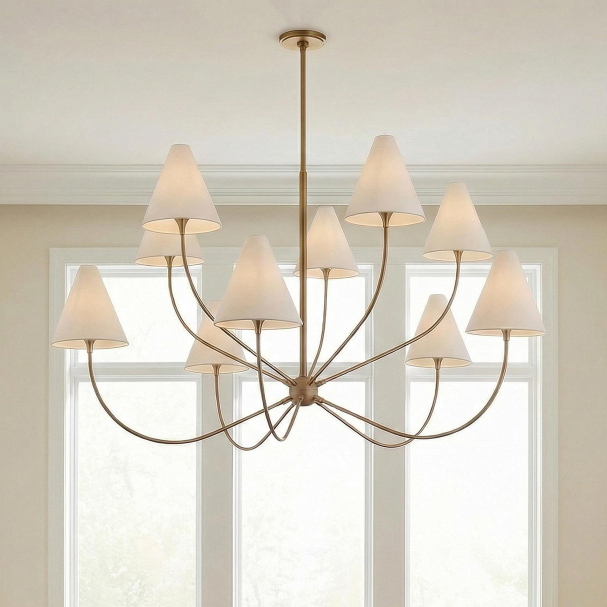 Yara 10 Light Chandelier 60", Patina Brass scalloped Chandelier in a Transitional Dining Room with large windows and neutral walls.