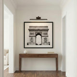 Roland LED Picture Light 24", Bronze linear Wall Sconce in a Transitional Hallway with a walnut console table and framed art.