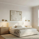 Kelsie Swing Arm LED Wall Sconce, Aged Brass geometric Wall Sconce in a Contemporary Bedroom with a cream bed and oak nightstand.