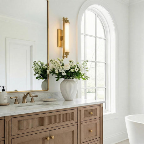 Empire LED Aged Brass linear wall sconce in a Transitional Bathroom with a ribbed wood vanity and marble countertop.