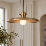 A transitional kitchen features the Titan Large Pendant 24", Patina Brass with a frosted glass globe, suspended near off-white paneled cabinetry and brass door hardware.