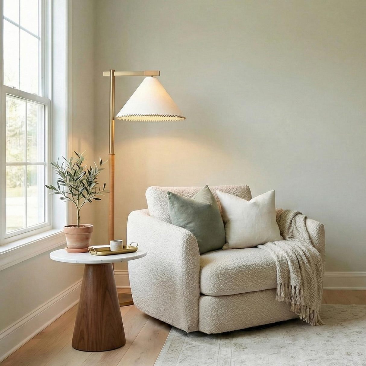 Delora Floor Lamp 60", Patina Brass and Rattan scalloped Floor Lamp in a Transitional Living Room with a cream bouclé chair.