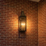 Dante Outdoor Wall Light, Large 24", Black and Brass geometric Outdoor Wall in a Traditional Outdoor space with a red brick wall.