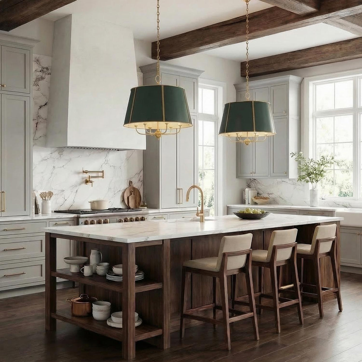 A transitional kitchen features two Avery 6 Light Extra Large Pendants 28", Forest Green and Aged Brass over a marble island with gray cabinetry and ceiling beams.