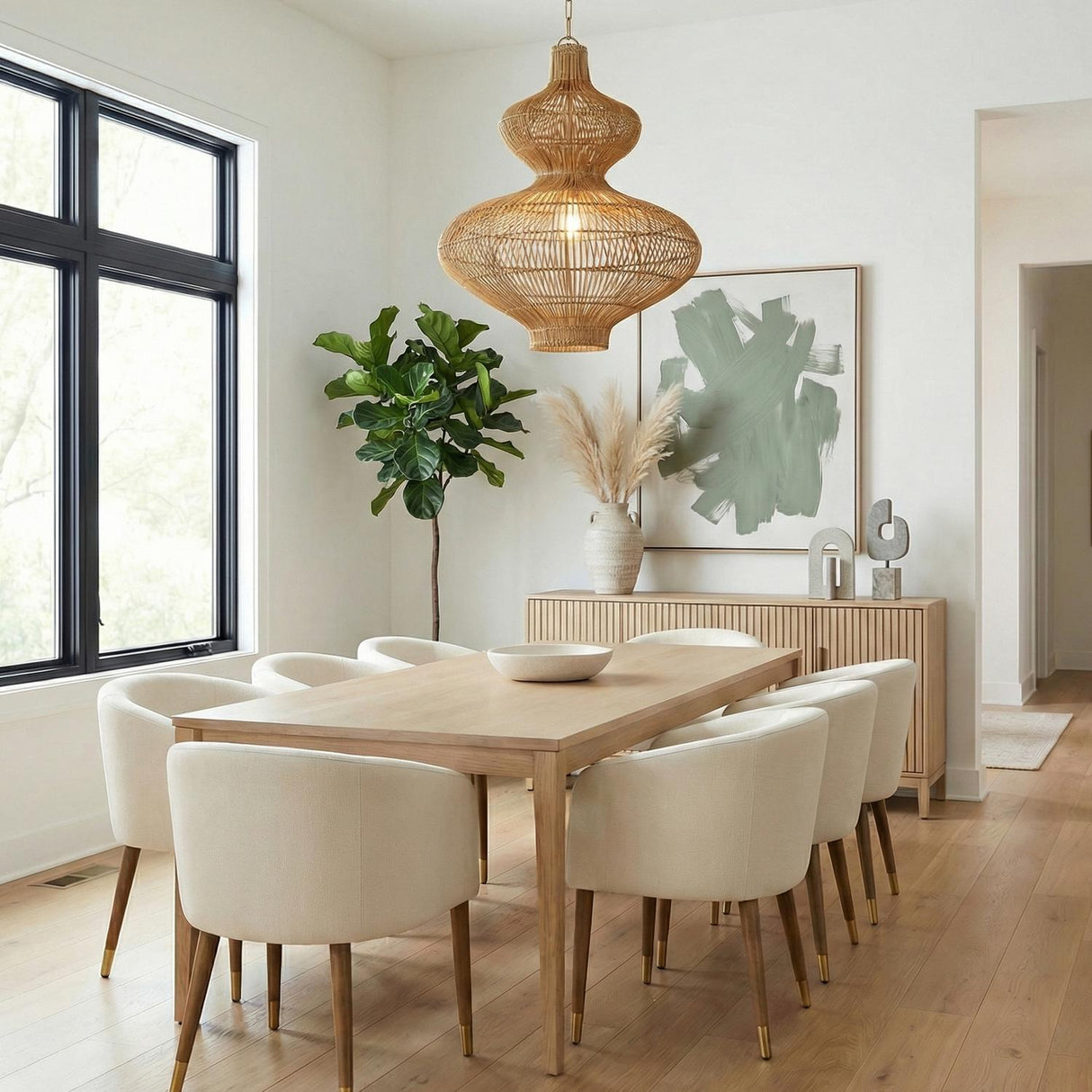 Jaffa Large Pendant 28", Rattan and Patina Brass woven Pendant in a Contemporary Dining Room with a light wood table and white chairs.