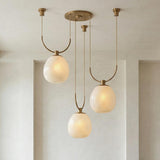 Orly 3 Light Swag Chandelier 36", Patina Brass and Seeded Cloud Glass globe chandelier in a Contemporary Entryway with recessed niches.