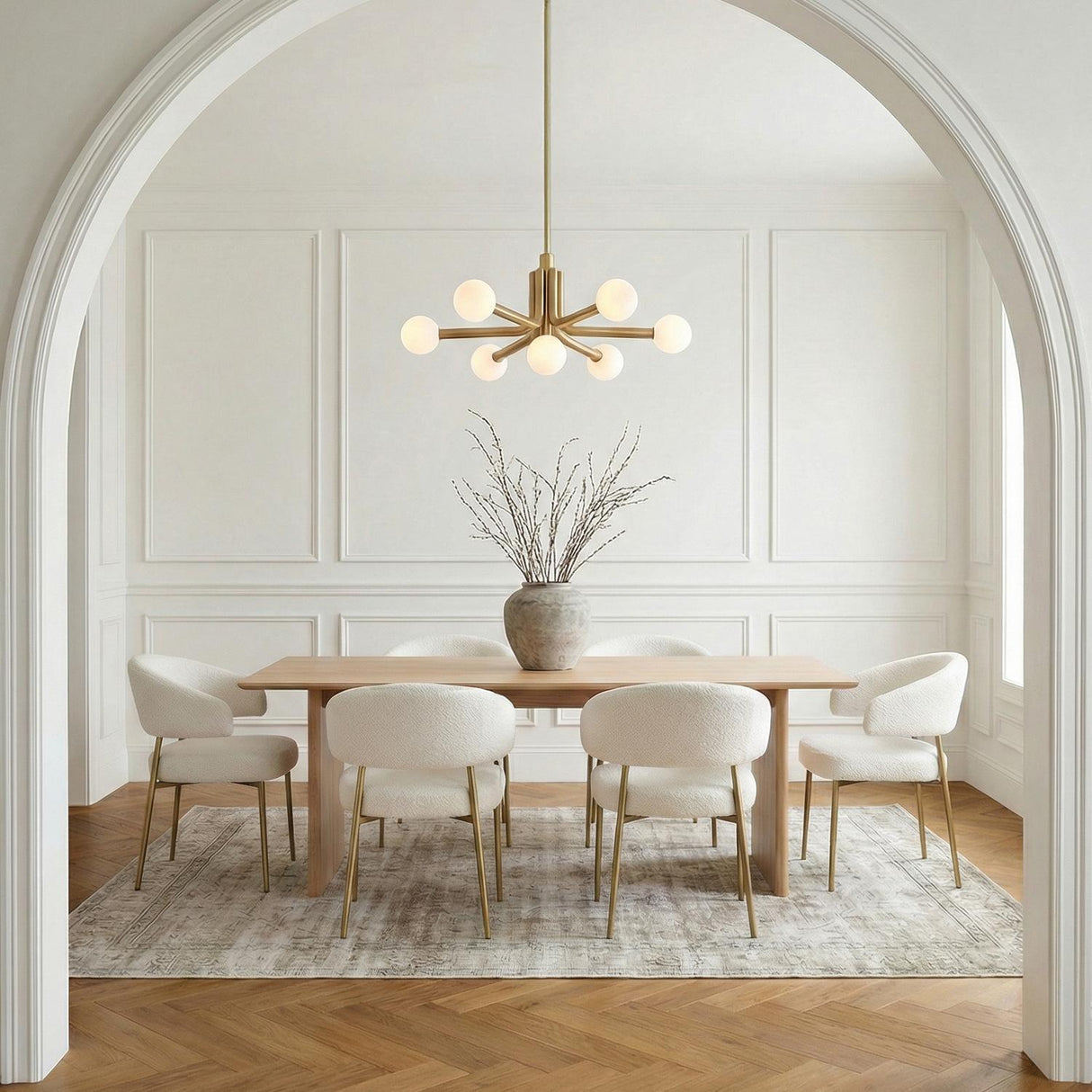 Maribel 7 Globe Chandelier 29", Satin Brass globe Chandelier in a Contemporary Dining Room with white boucle chairs and a wood table.