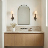 Valen Wall Sconce 19", Forged Bronze leaf design wall sconce in a Transitional Bathroom with an arched mirror and marble backsplash.