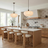 Uma Fabric Pendant 22", Bronze scalloped Pendant in a Transitional Kitchen with a white marble island and boucle bar stools.