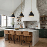 Kitchen featuring Drew Medium Pendant 19", Matte Black and Aged Brass over a marble waterfall island with woven barstools and green cabinetry under a sloped ceiling.