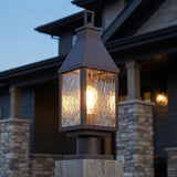 A craftsman home exterior with a Westin Outdoor Post Light 20", Bronze and Water Glass lantern on a wooden post near stacked stone pillars.