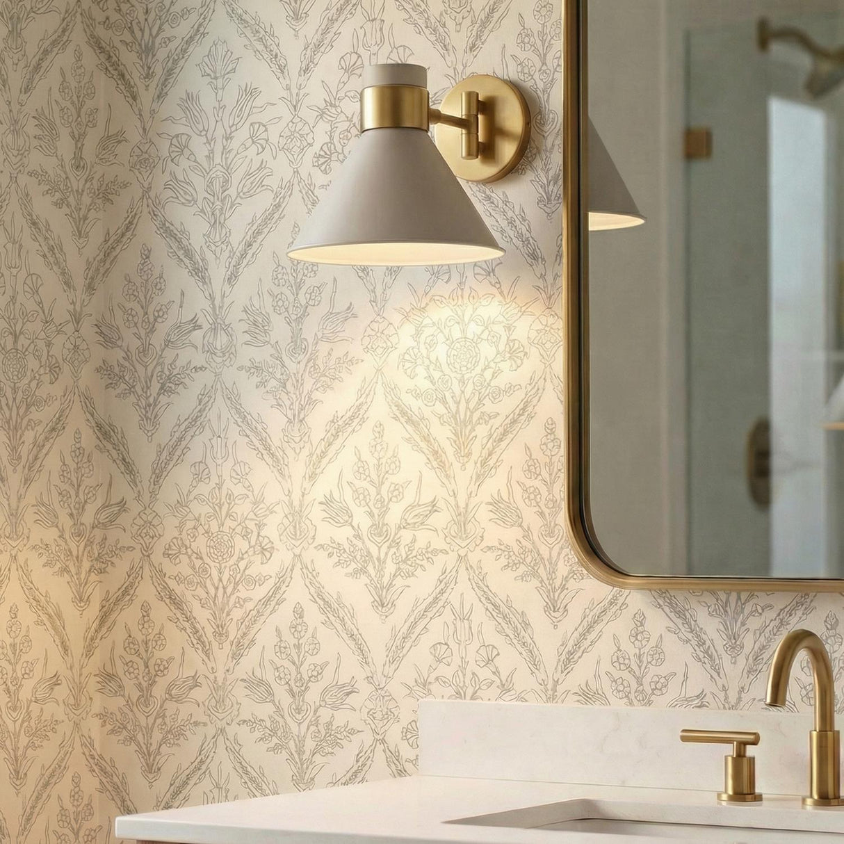 Cosette Adjustable Wall Sconce 8", Soft Taupe and Antique Brass geometric Wall Sconce in a Transitional Bathroom with patterned wallpaper.