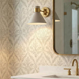 Cosette Adjustable Wall Sconce 8", Soft Taupe and Antique Brass geometric Wall Sconce in a Transitional Bathroom with patterned wallpaper.