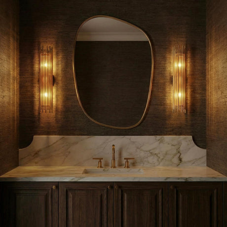 Vesper Gold linear Wall Sconce in a Contemporary Bathroom with a white marble vanity and organic mirror.