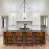 Jada White scalloped conical pendant in a Modern Farmhouse Kitchen with a white marble backsplash and leather barstools.